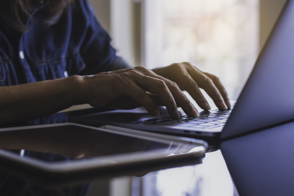 Hands typing on a computer keyboard