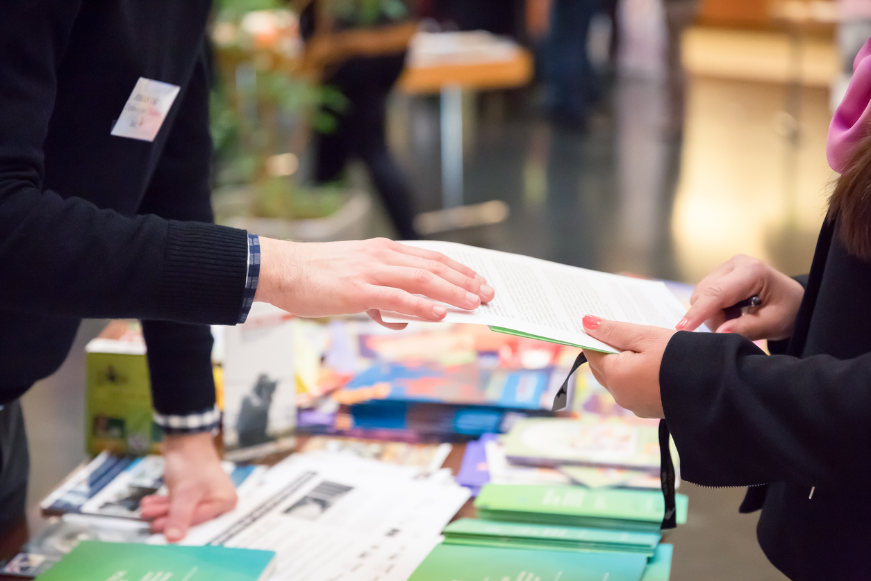 Photo of handing an informational guide from one person to another